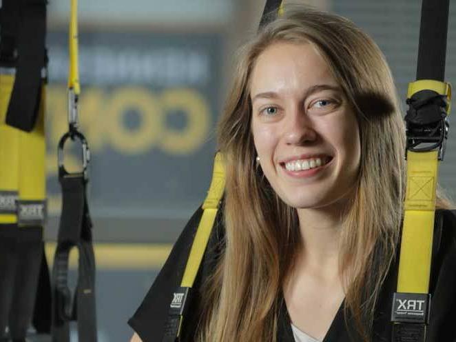 Woman is strapped into safety gear smiling for picture