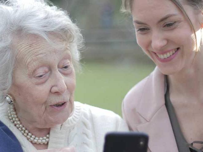 一个女人和一个年长的女人看着手机交流